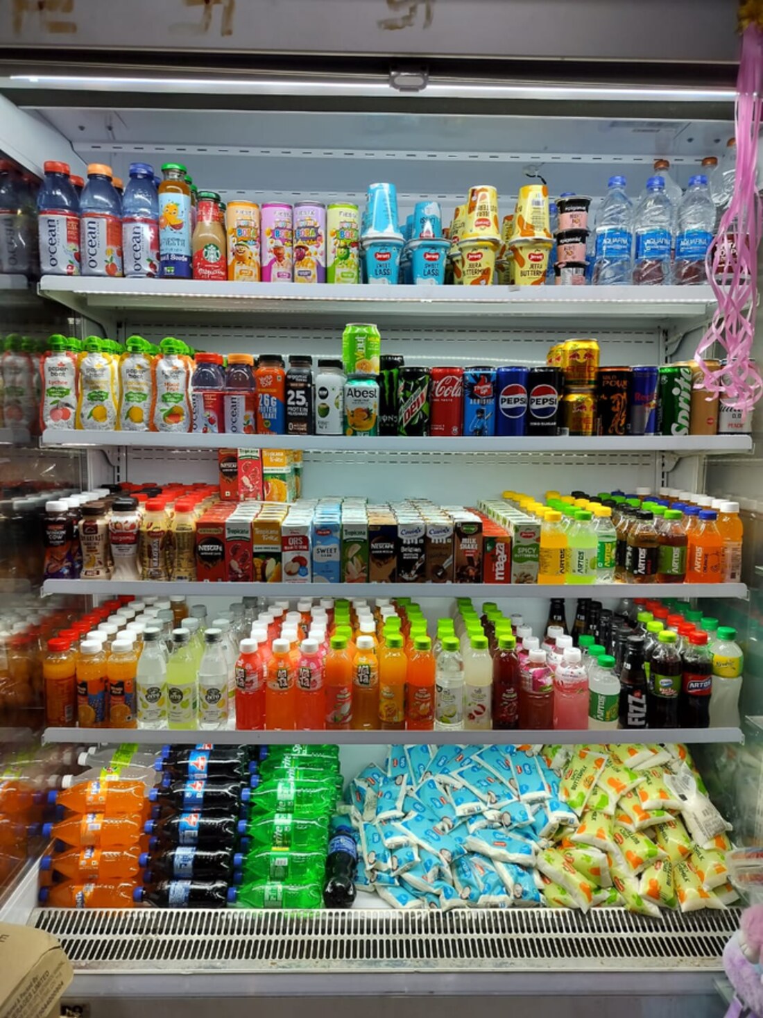 Refrigerated shelves stocked with beverages, juices and soft drinks